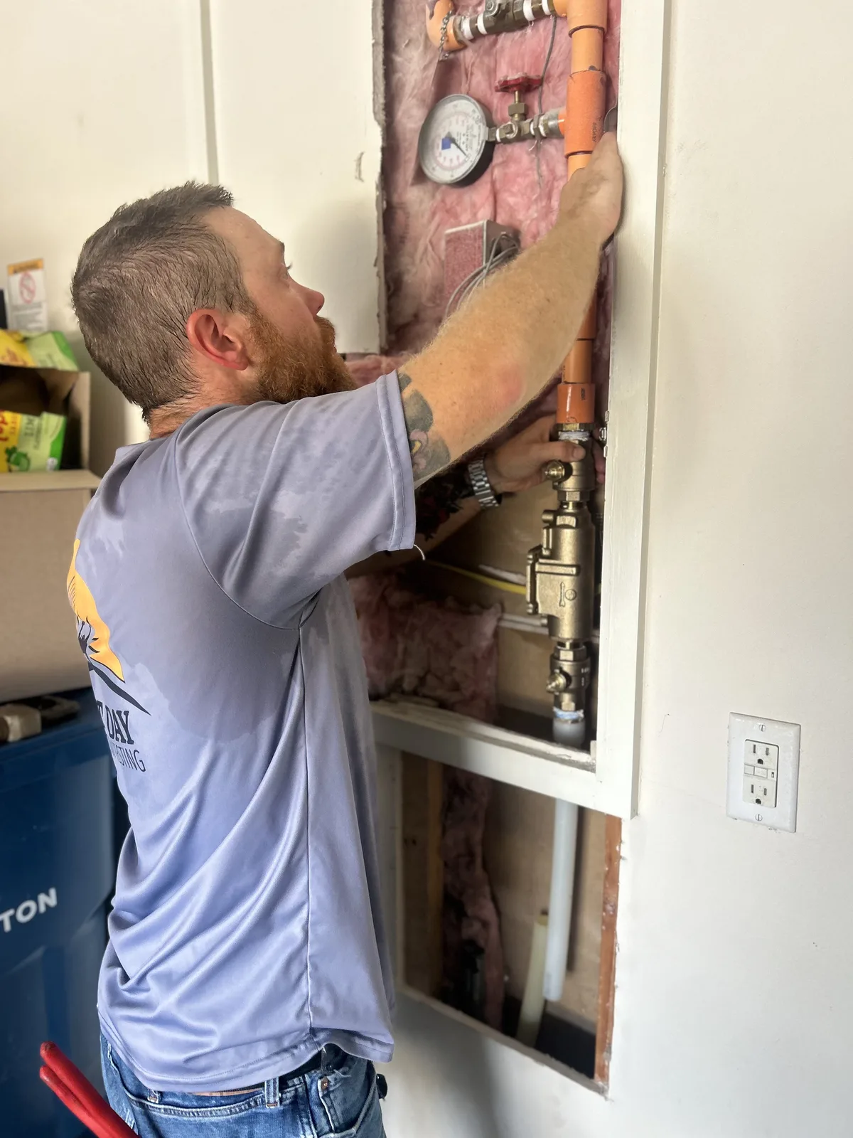 Next Day Backflow Testing technician working on a residential fire sprinkler backflow assembly in a garage